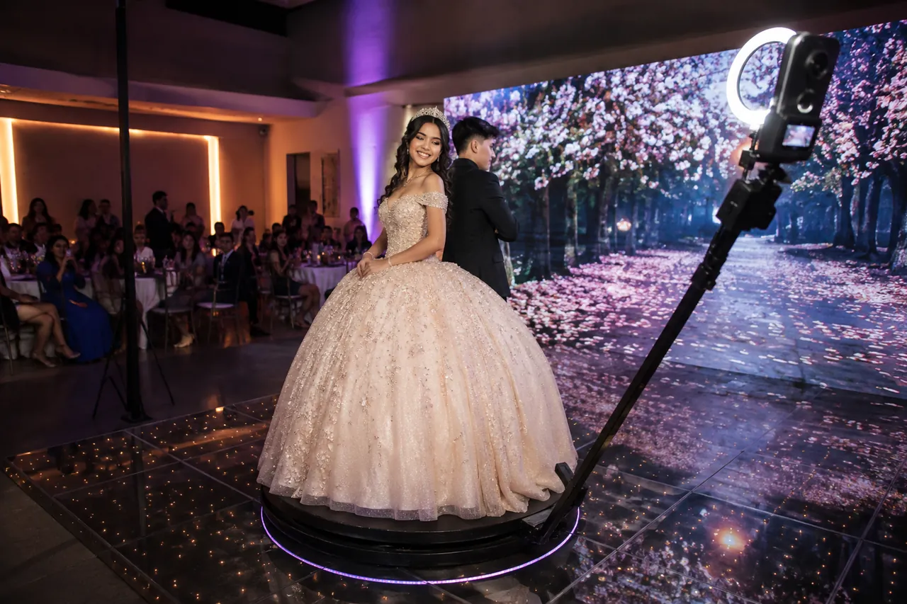 A quinceañera and her escort on the 360 platform in front of an LED wall