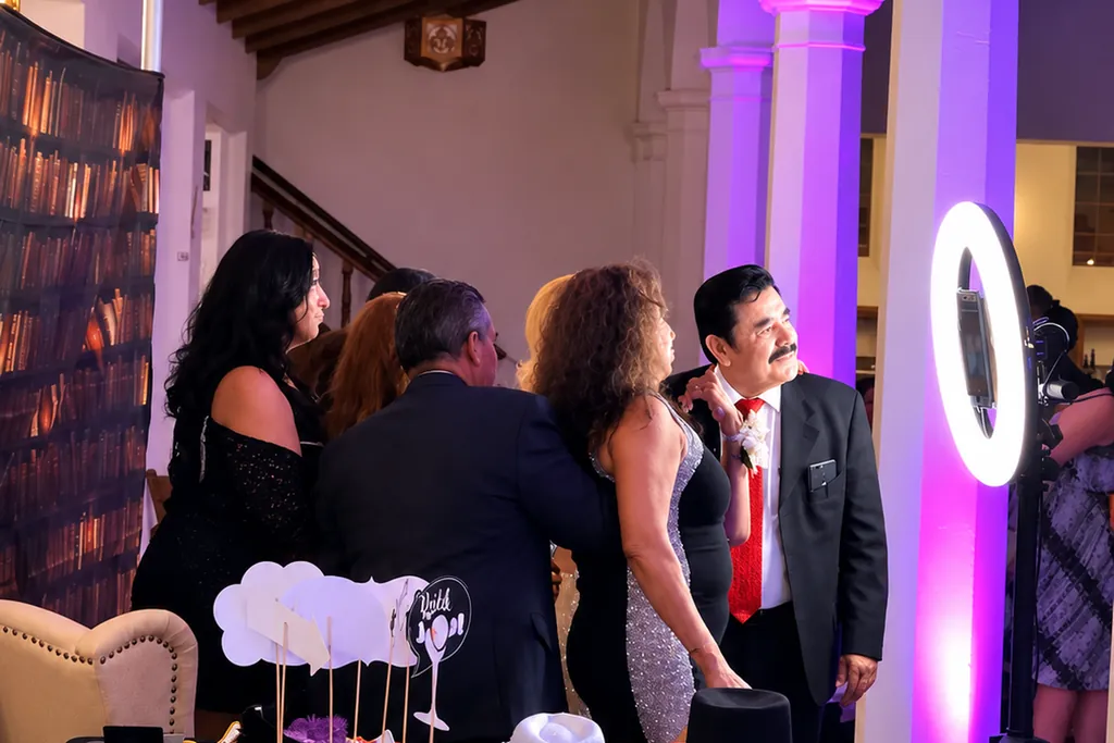 Guests lining up at the social booth ring light in a purple-lit hall