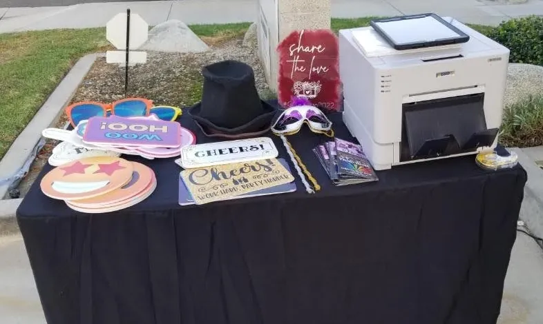 A props table with signs, hats and glasses beside the photo printer