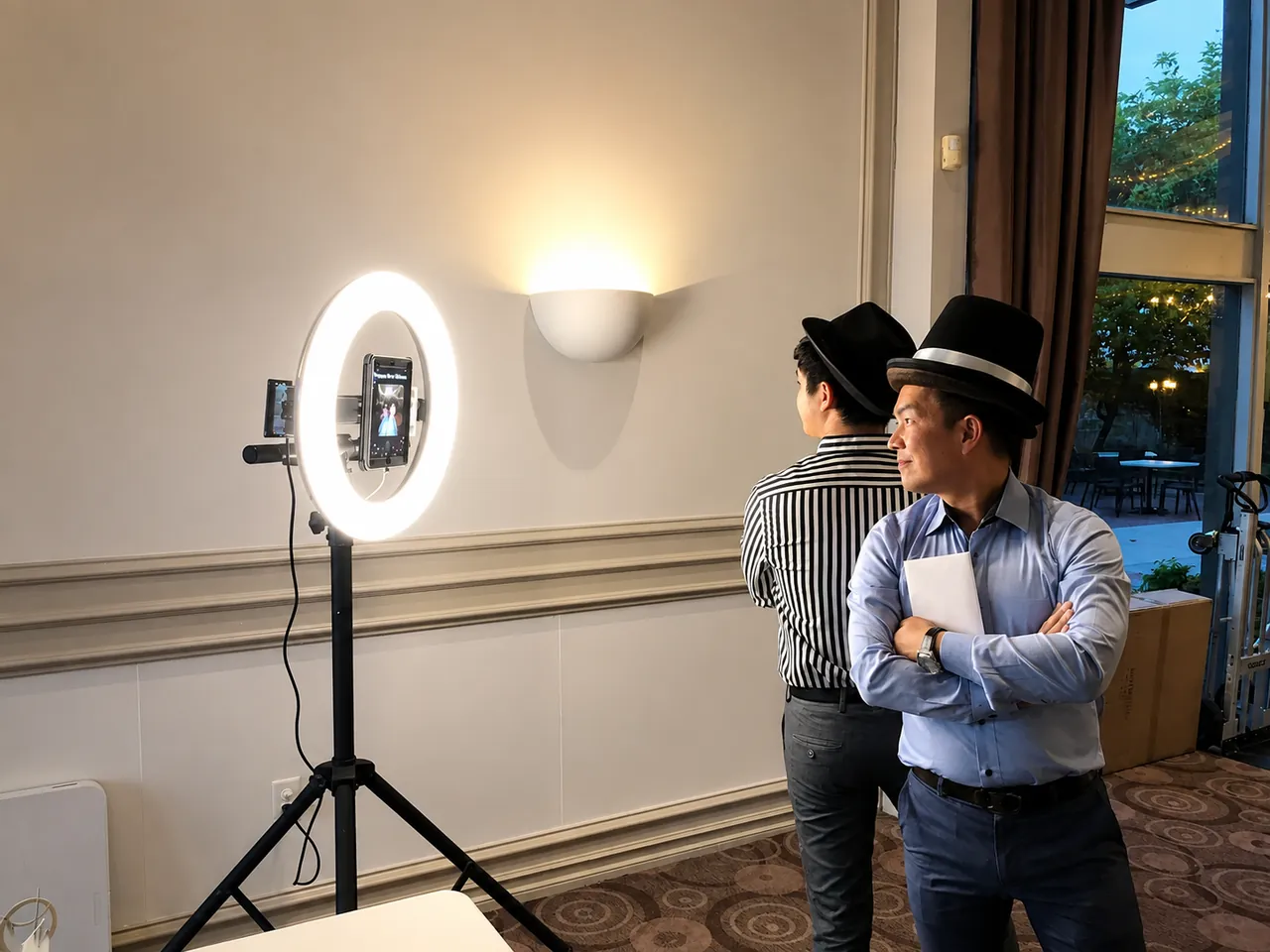 Two guests in top hats posing at a ring-light booth
