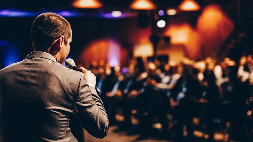 A speaker addressing a crowd at a corporate event