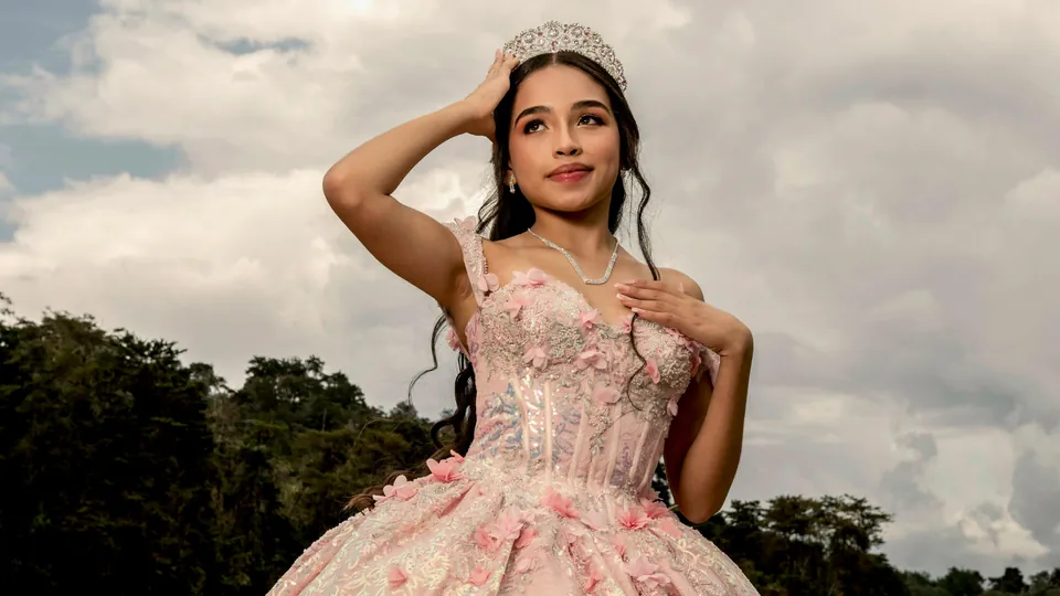 A quinceañera in a pink gown and tiara